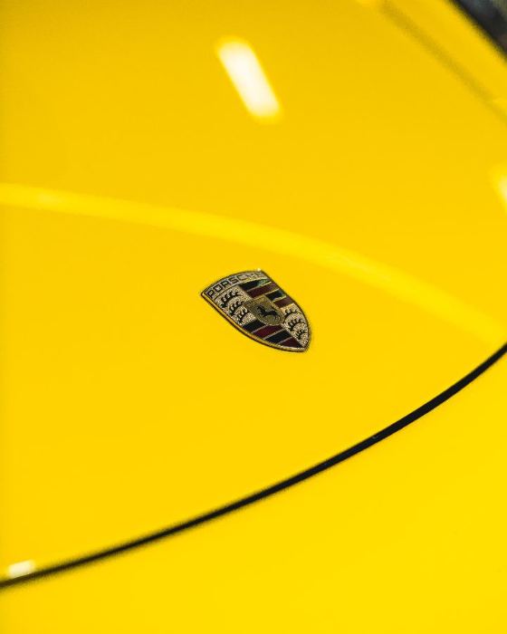 Emblema da Porsche no capô amarelo