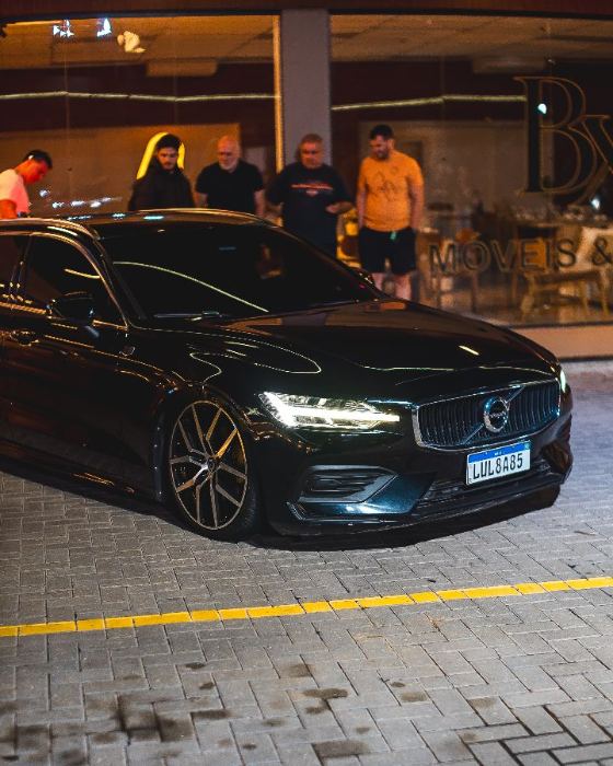 Volvo preto com a galera ao fundo