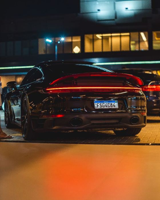 Traseira de um Porsche preto à noite