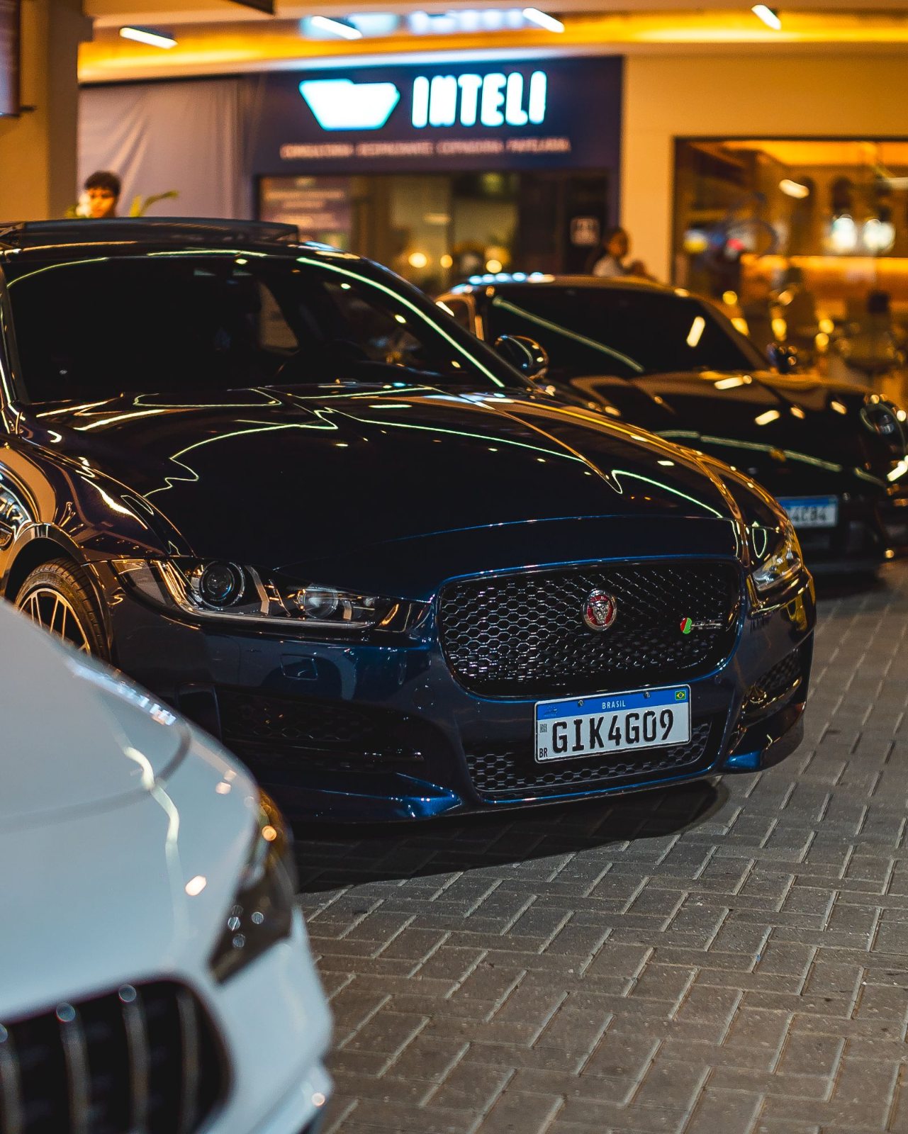 Jaguar XE azul escuro alinhado com outros carros no encontro