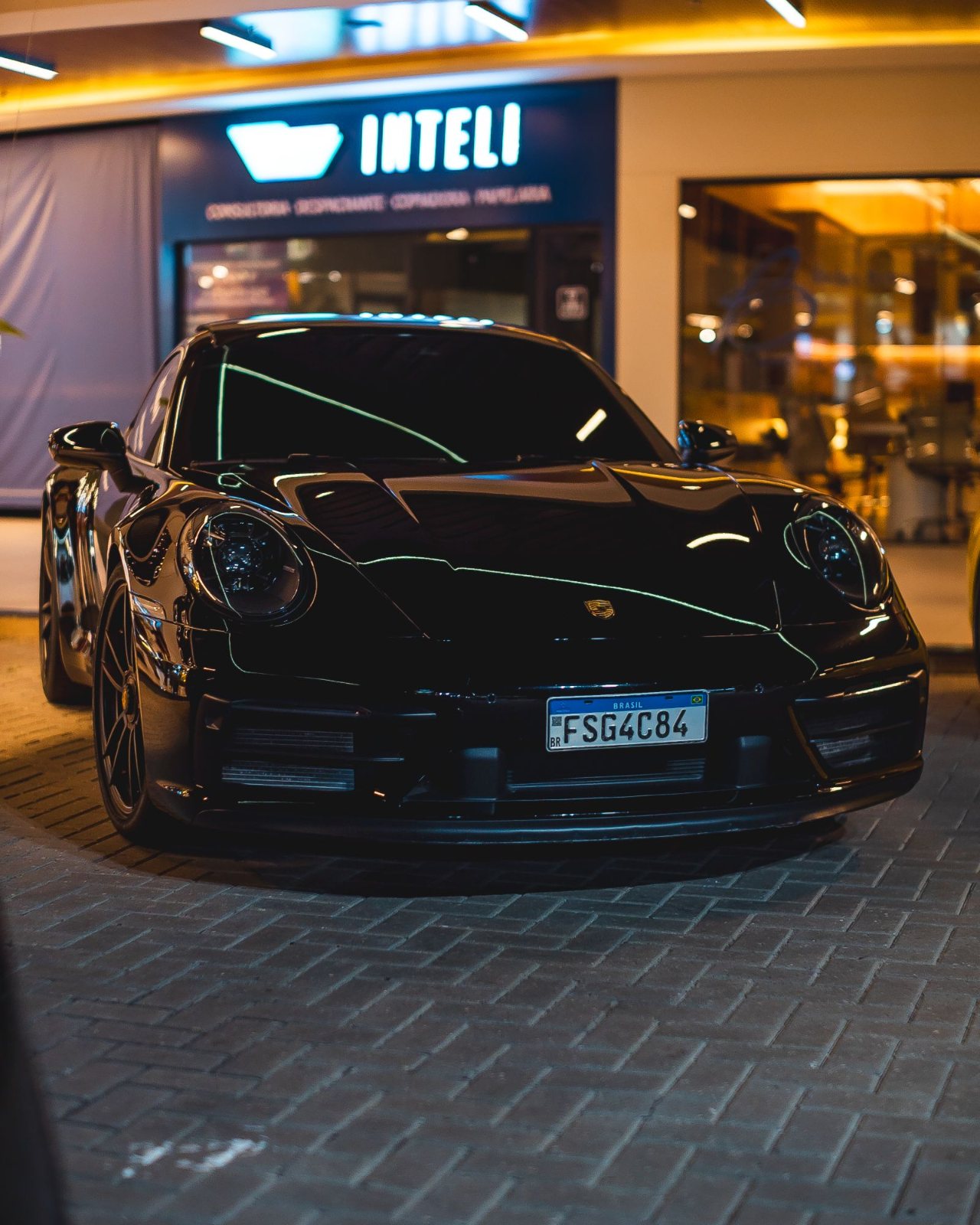 Porsche 911 preto estacionado num encontro do clube à noite